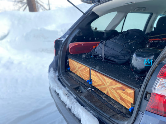 camper bed with drawers inside subaru in snow