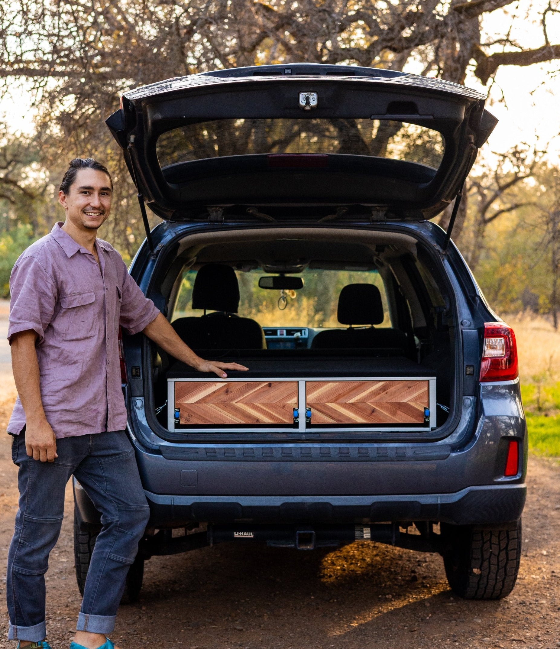 owner person standing in front of compass camper conversion kit in the forest