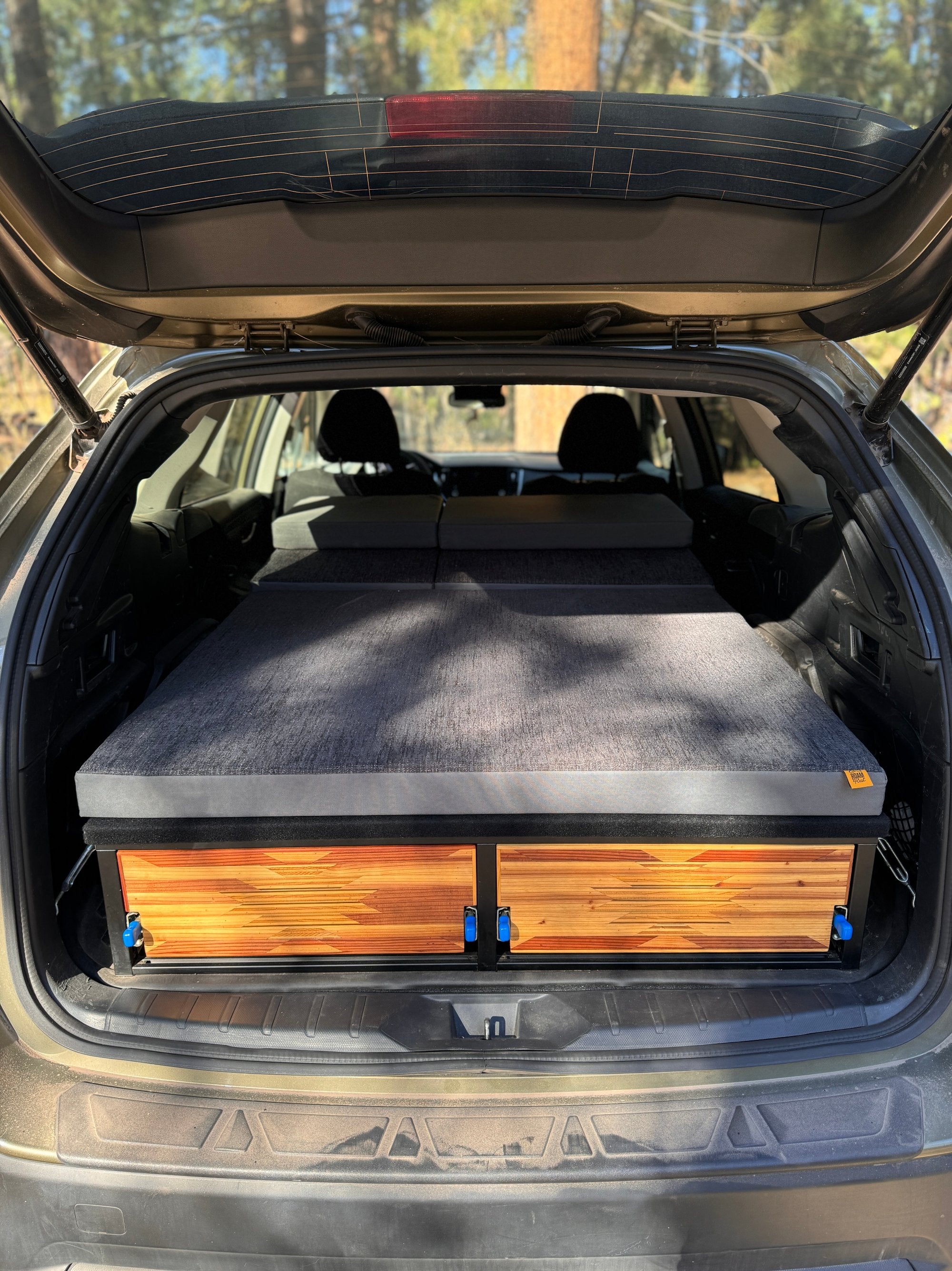 camper conversion kit bed platform inside subaru outback with custom mattress on top and mosaic drawer faces